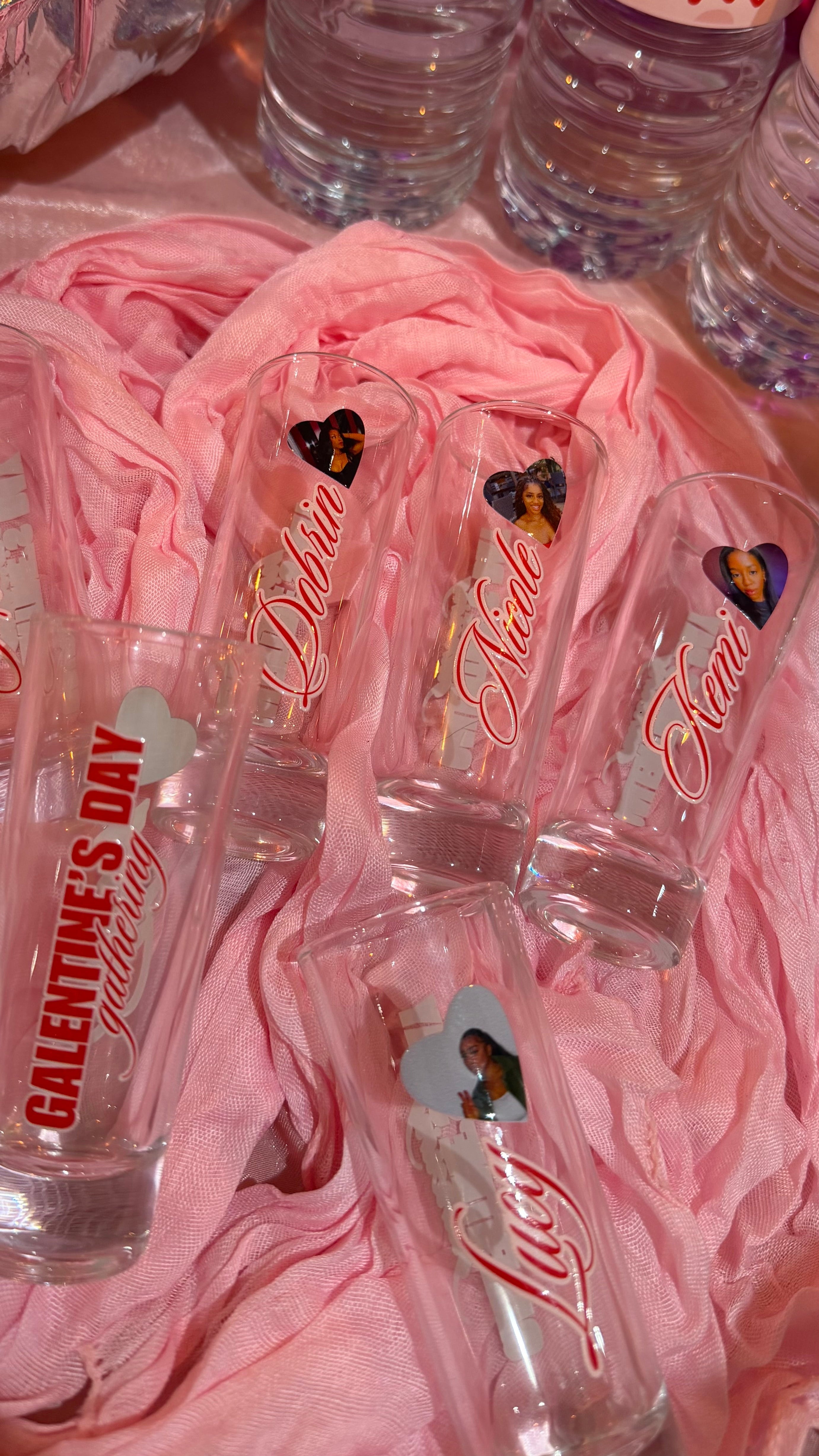 Clear water bottles with Valentine's Day designs on pink fabric